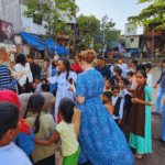 Travelers interacting with local children during a community visit in Dharavi Mumbai