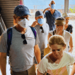 Travelers observing a small textile or material workshop during a guided tour in Mumbai
