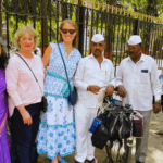 Travelers meeting Mumbai dabbawalas during a cultural walking tour experience in Mumbai