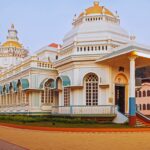 Traditional Hindu temple in Goa with white domes and golden spires