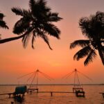 Chinese fishing nets silhouetted against sunset in Kochi backwaters near Kumbalangi