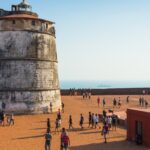 Aguada Fort lighthouse with tourists overlooking Arabian Sea Goa
